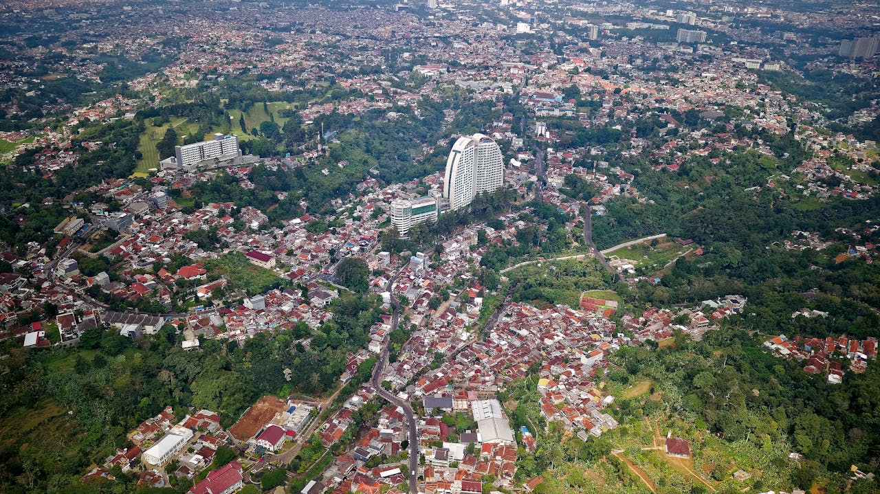 services-04 Expansive aerial view of Cimaung, Indonesia, showcasing cityscape with lush greenery and architecture.